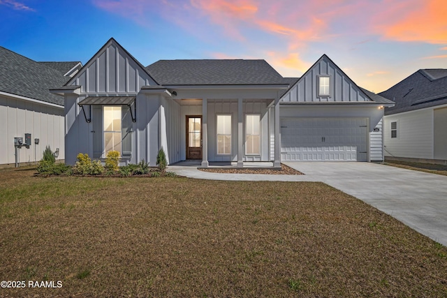 modern farmhouse style home featuring a garage, a shingled roof, driveway, a yard, and board and batten siding