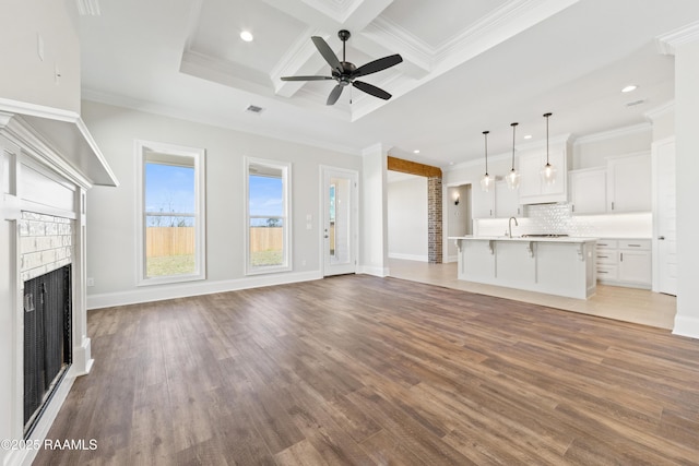 unfurnished living room with crown molding, a fireplace, and wood finished floors