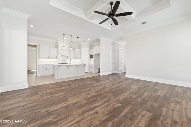 unfurnished living room featuring ornamental molding, wood finished floors, visible vents, and a ceiling fan