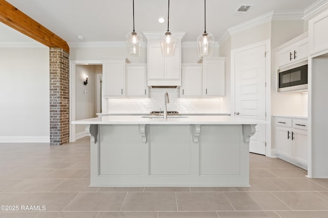 kitchen with visible vents, built in microwave, light countertops, and crown molding