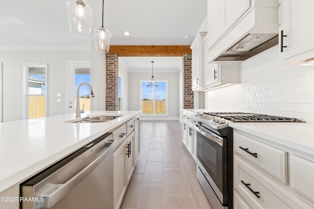 kitchen featuring crown molding, stainless steel appliances, light countertops, decorative backsplash, and a sink