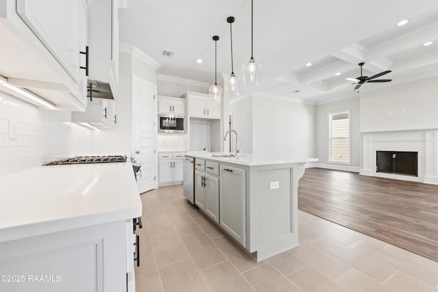 kitchen with ceiling fan, a sink, open floor plan, appliances with stainless steel finishes, and tasteful backsplash