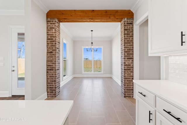 unfurnished dining area with baseboards and crown molding