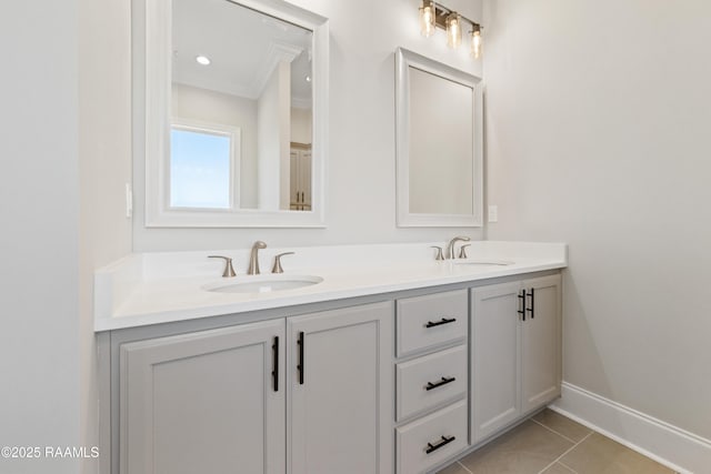 full bathroom with baseboards, double vanity, a sink, and tile patterned floors