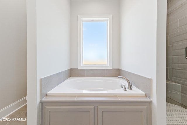 bathroom with a stall shower, a bath, and tile patterned floors