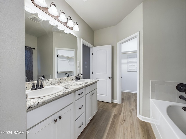 bathroom featuring a bathing tub, wood-type flooring, and vanity