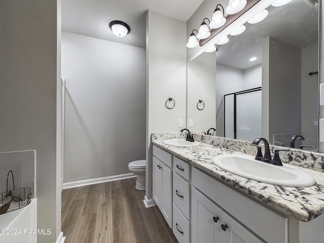 bathroom featuring toilet, vanity, hardwood / wood-style flooring, and walk in shower