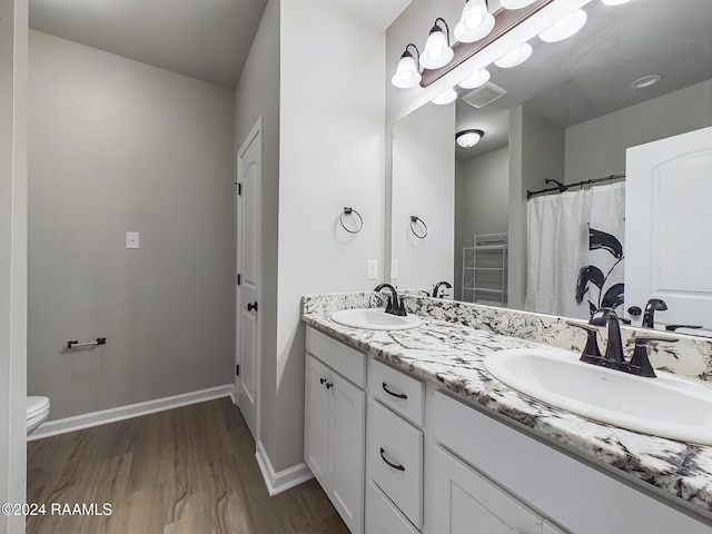 bathroom featuring wood-type flooring, vanity, and toilet