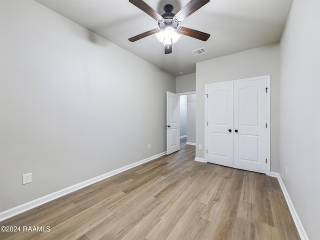 unfurnished bedroom with a closet, ceiling fan, and light hardwood / wood-style flooring