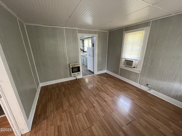 spare room featuring hardwood / wood-style flooring, cooling unit, heating unit, and wooden walls