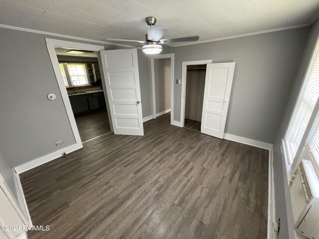 unfurnished bedroom featuring crown molding, ceiling fan, and dark hardwood / wood-style flooring