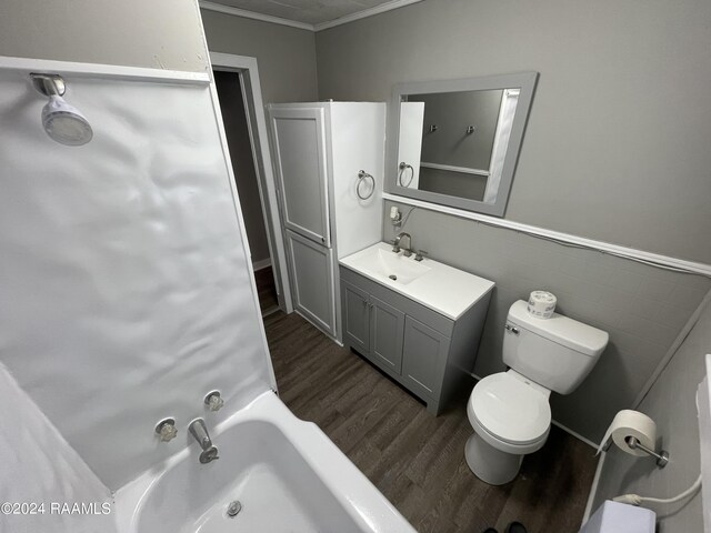 bathroom featuring a tub, hardwood / wood-style flooring, toilet, ornamental molding, and vanity