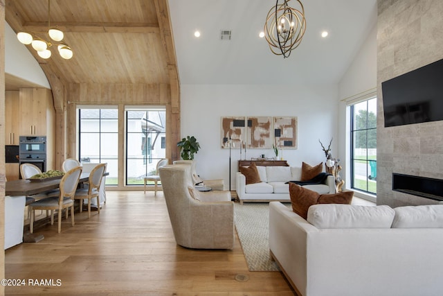 living room featuring a fireplace, an inviting chandelier, light hardwood / wood-style flooring, wood ceiling, and high vaulted ceiling