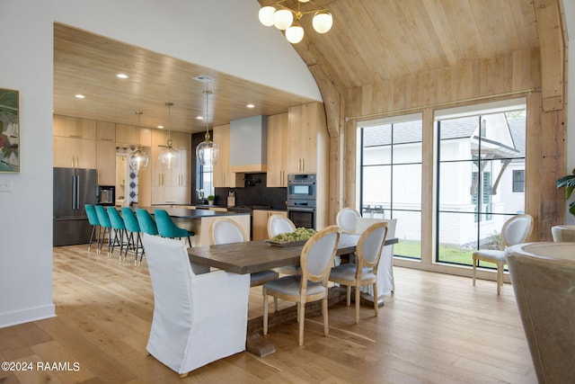 dining area featuring vaulted ceiling, light hardwood / wood-style flooring, a notable chandelier, wood ceiling, and sink