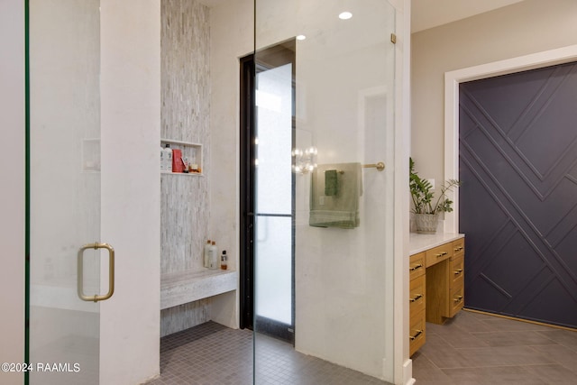 bathroom featuring tile patterned floors, a shower with shower door, and vanity