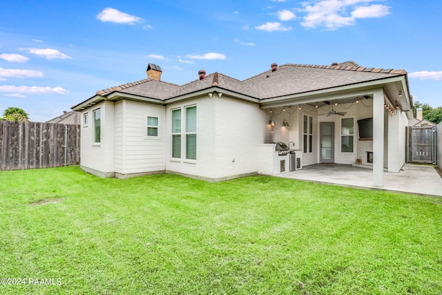 rear view of property featuring ceiling fan, a lawn, and a patio area