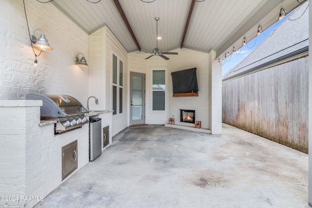 view of patio with grilling area, an outdoor kitchen, sink, and ceiling fan