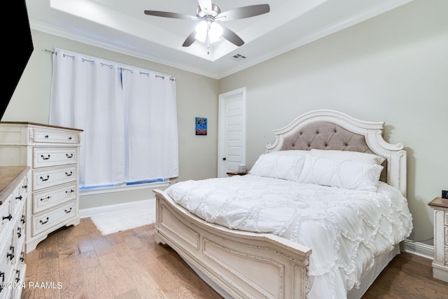 bedroom featuring ceiling fan, ornamental molding, and light wood-type flooring