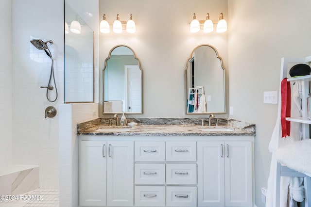 bathroom featuring a tile shower and vanity