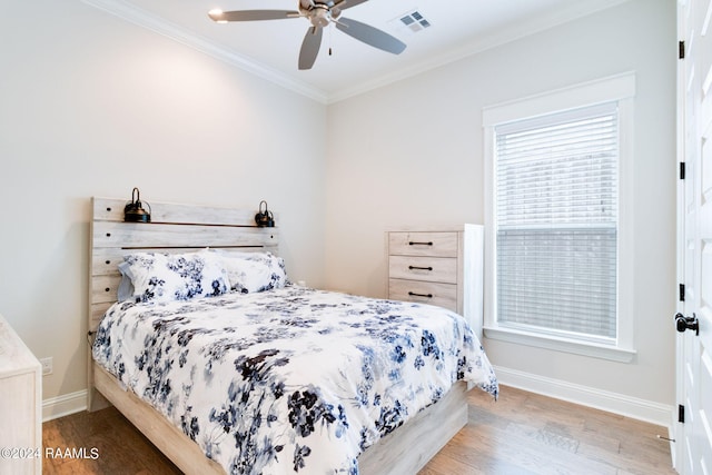 bedroom with hardwood / wood-style floors, ceiling fan, and crown molding