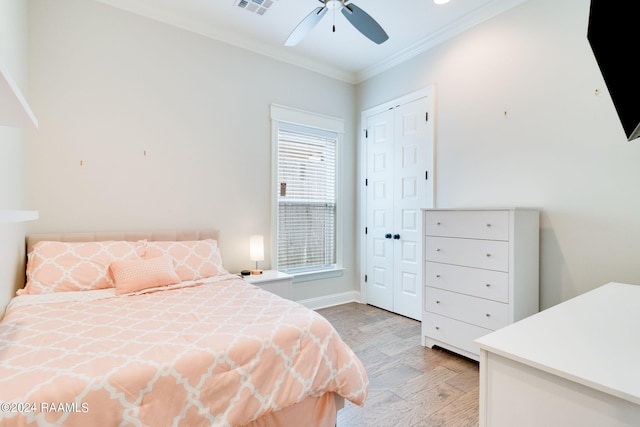 bedroom with a closet, ceiling fan, ornamental molding, and light hardwood / wood-style flooring