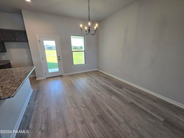 unfurnished dining area with a chandelier and hardwood / wood-style floors