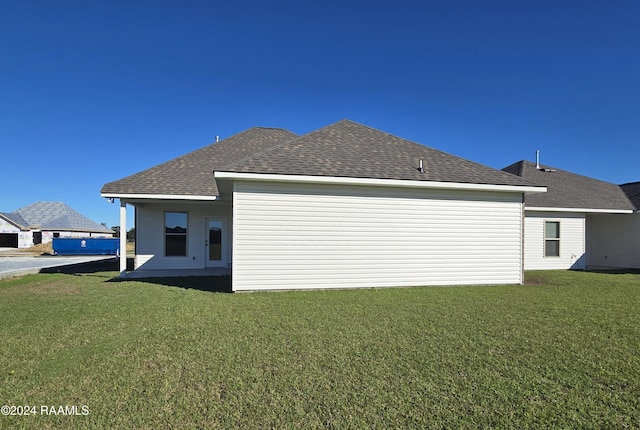 rear view of property featuring a lawn