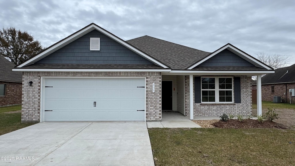 view of front of property with cooling unit, a garage, and a front lawn