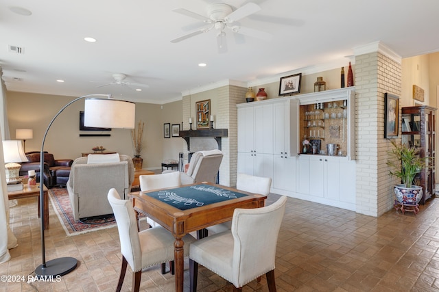 dining area featuring crown molding, brick wall, and ceiling fan