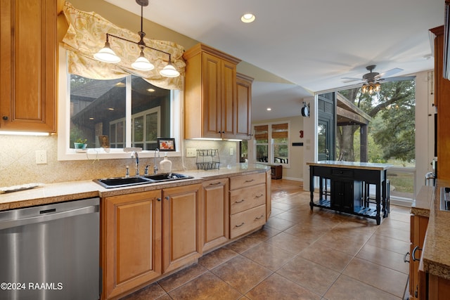 kitchen featuring sink, backsplash, dishwasher, and hanging light fixtures