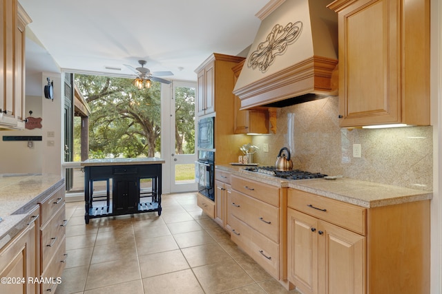 kitchen featuring light brown cabinets, decorative backsplash, premium range hood, and ceiling fan