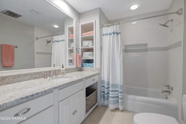 full bathroom with vanity, shower / tub combo with curtain, and toilet