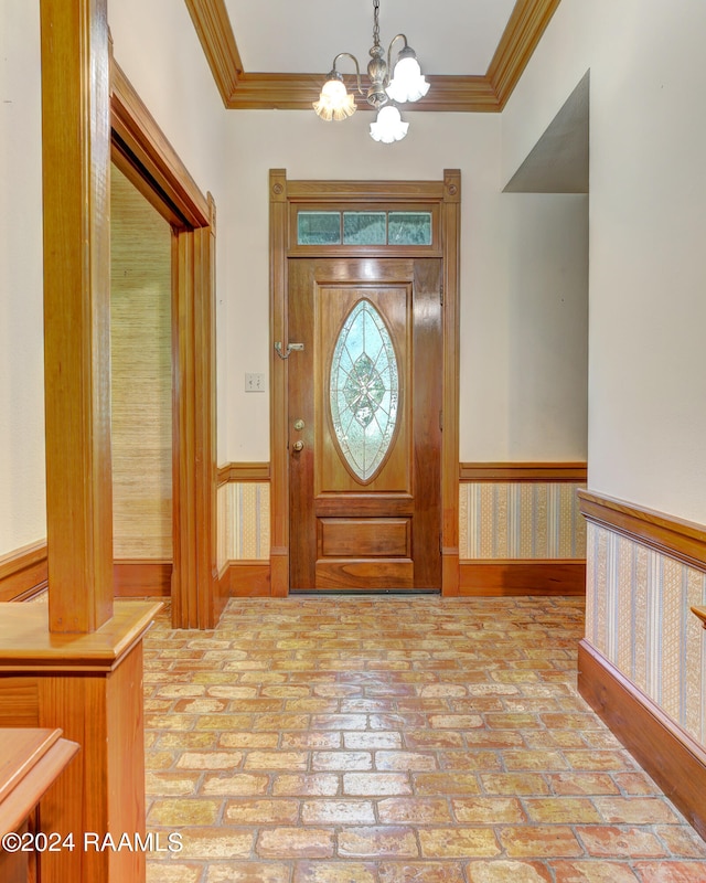 entryway featuring crown molding and a chandelier