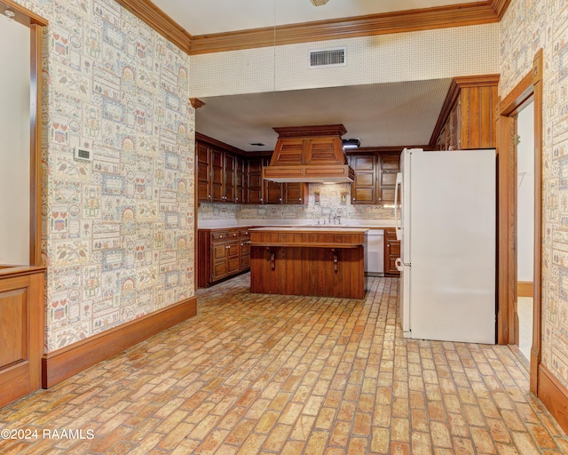 kitchen with premium range hood, white refrigerator, a center island, crown molding, and stainless steel dishwasher