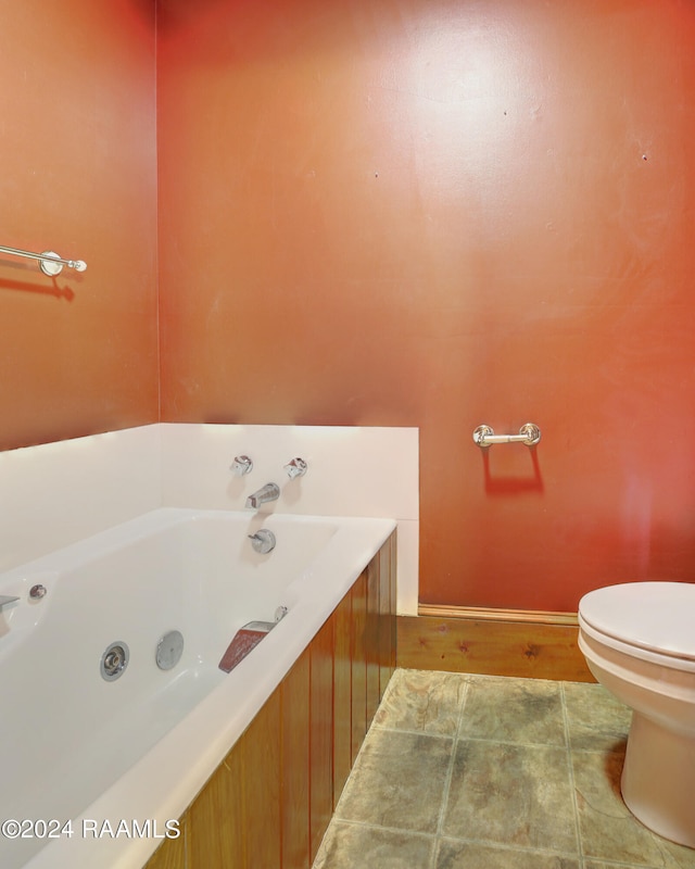 bathroom featuring tile patterned floors, a tub, and toilet