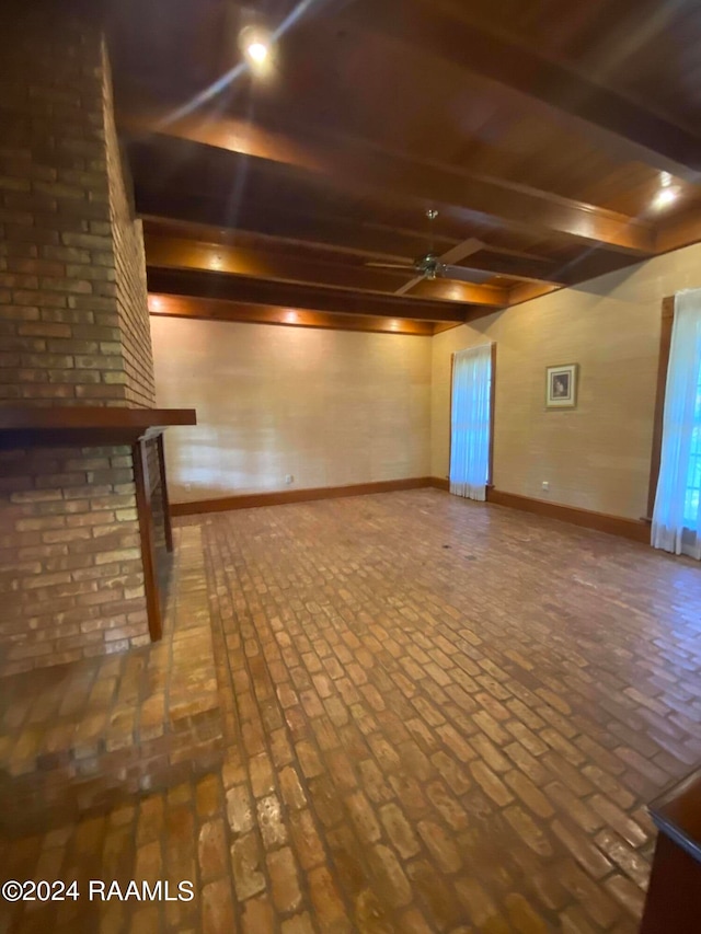 unfurnished living room with ceiling fan and beamed ceiling