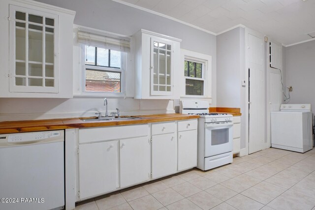 kitchen with washer / dryer, white appliances, white cabinetry, and sink