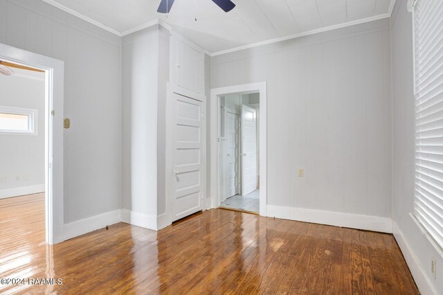 unfurnished bedroom featuring crown molding, hardwood / wood-style flooring, and ceiling fan