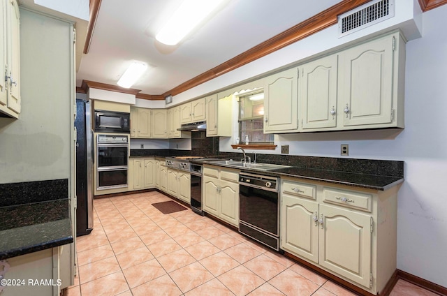 kitchen featuring dark stone counters, sink, black appliances, light tile patterned floors, and crown molding