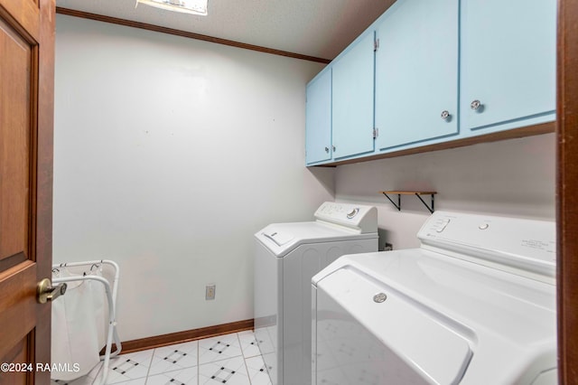 clothes washing area featuring a textured ceiling, cabinets, crown molding, and washing machine and clothes dryer