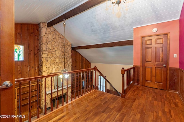 corridor featuring lofted ceiling with beams, wood ceiling, wood walls, and hardwood / wood-style floors