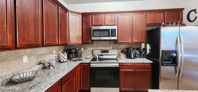 kitchen with appliances with stainless steel finishes, decorative backsplash, and light stone countertops