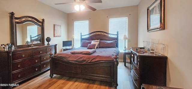 bedroom with ceiling fan, light hardwood / wood-style floors, and multiple windows