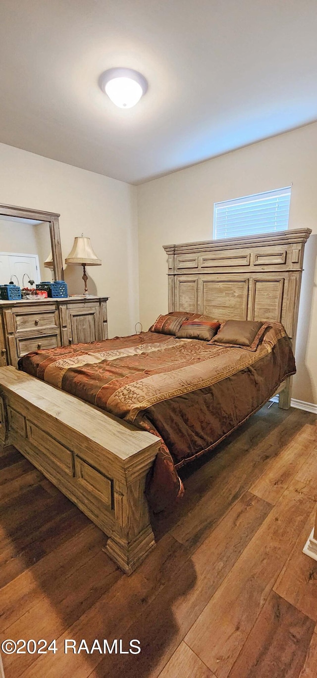 bedroom with dark hardwood / wood-style flooring