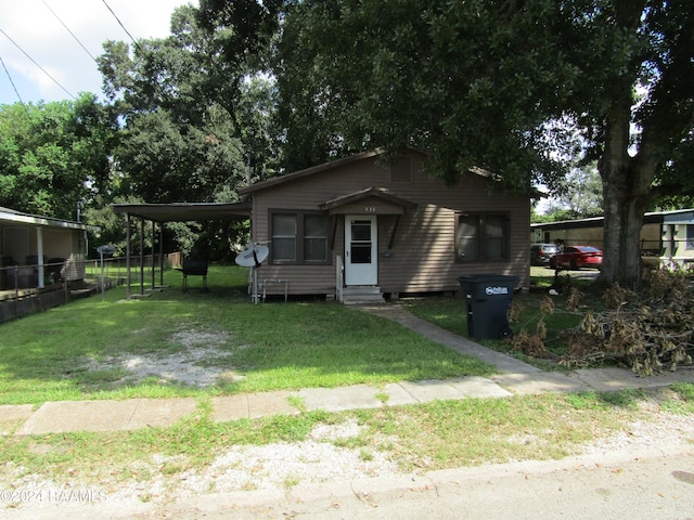 bungalow-style house with a front yard and a carport