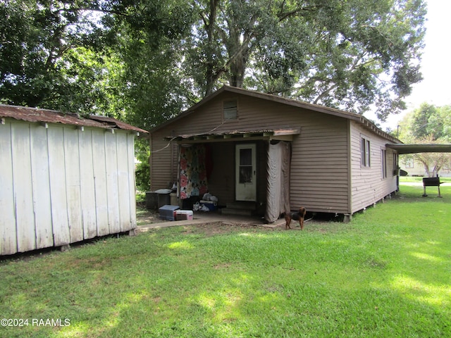 rear view of property featuring a lawn