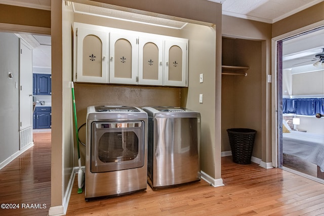 laundry area with cabinets, light wood-type flooring, crown molding, ceiling fan, and washing machine and dryer