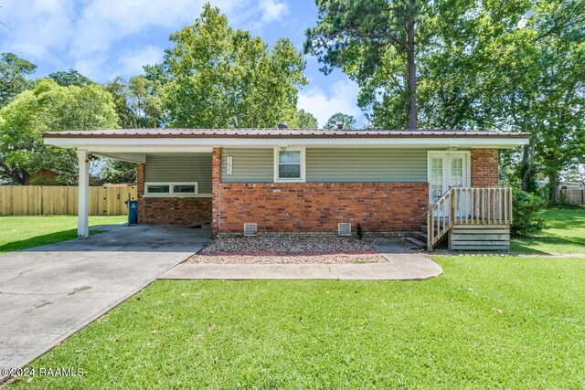 single story home with a front yard and a carport