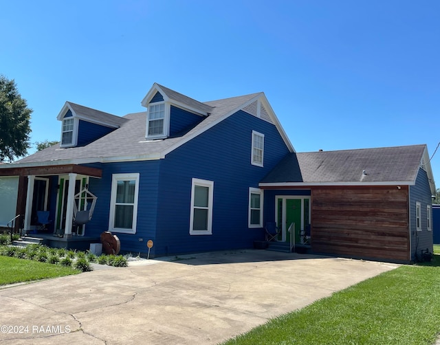 cape cod home featuring a porch and a front lawn