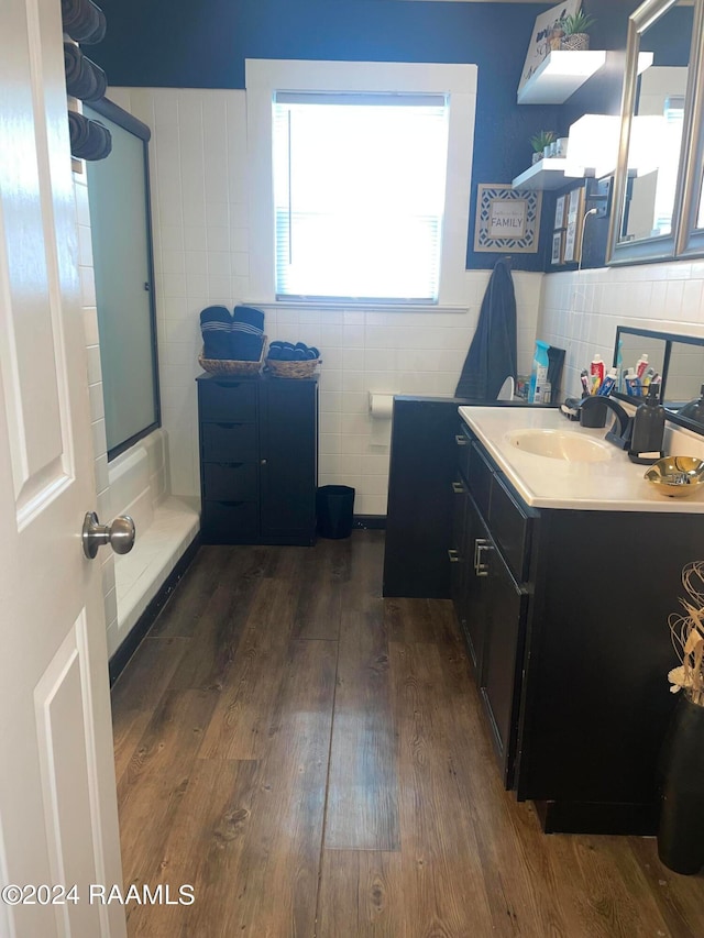 bathroom with hardwood / wood-style flooring, vanity, and a shower